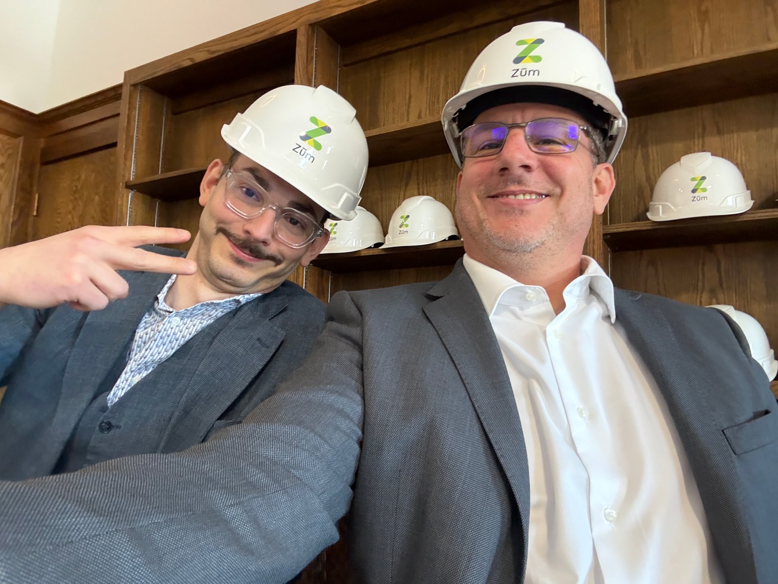 Two colleagues wearing hard hats and suits
